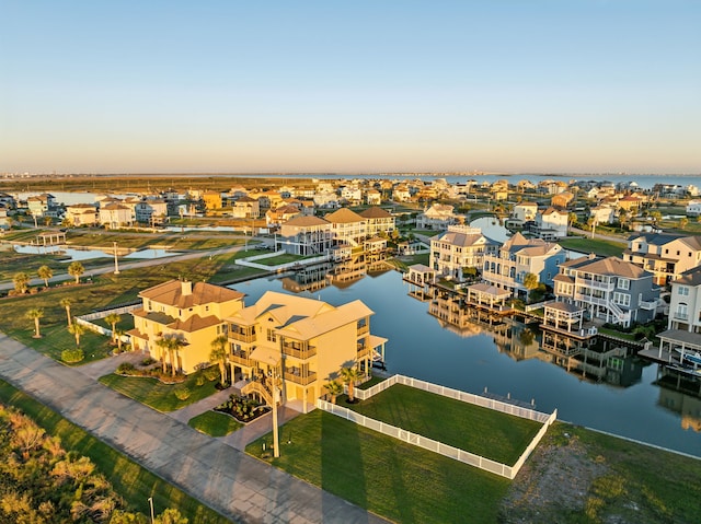 aerial view at dusk featuring a water view