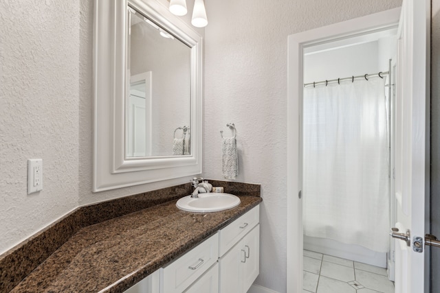 bathroom with shower / bath combo with shower curtain, vanity, and tile patterned flooring