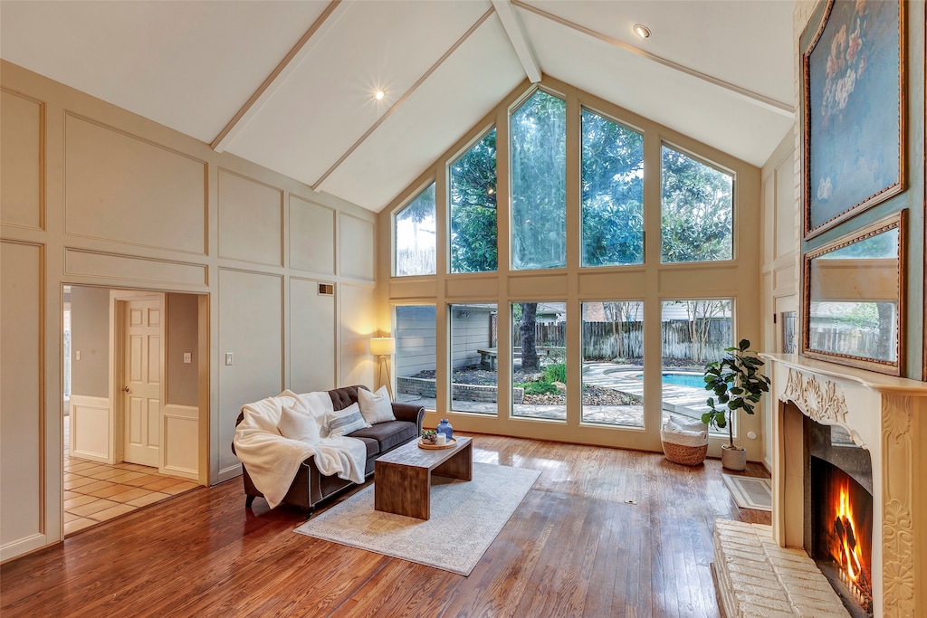 sunroom / solarium featuring vaulted ceiling with beams and a healthy amount of sunlight