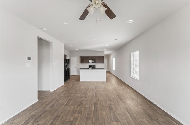 unfurnished living room with ceiling fan and dark wood-type flooring