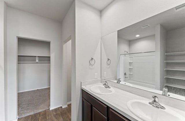 bathroom with washtub / shower combination, vanity, and hardwood / wood-style flooring