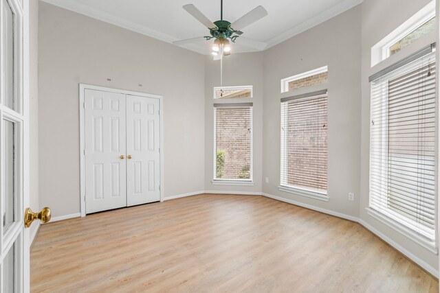 unfurnished bedroom featuring ceiling fan, a closet, crown molding, and light hardwood / wood-style flooring