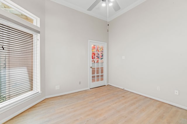 empty room featuring ceiling fan, light wood-type flooring, and crown molding