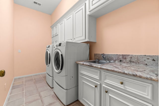 washroom with washer and dryer, cabinets, light tile patterned floors, and sink