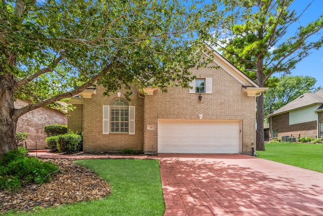 view of front of house featuring central AC unit, a garage, and a front yard