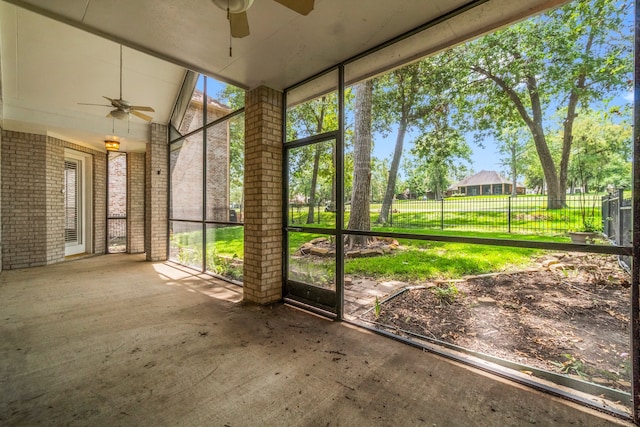 unfurnished sunroom with vaulted ceiling and ceiling fan