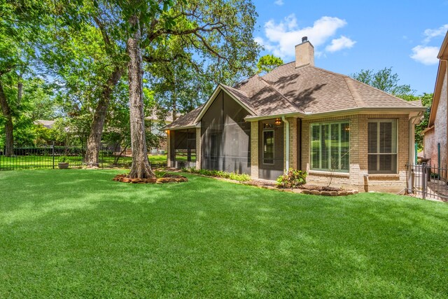 back of house with a sunroom and a yard