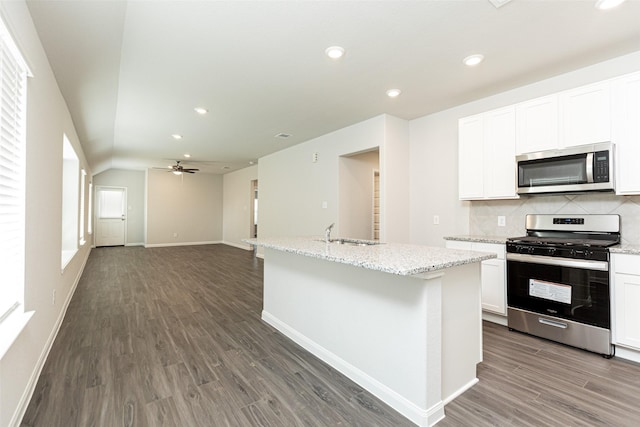 kitchen with ceiling fan, a center island with sink, white cabinets, and appliances with stainless steel finishes