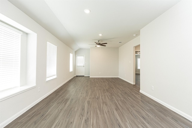 empty room with ceiling fan, dark hardwood / wood-style floors, and lofted ceiling