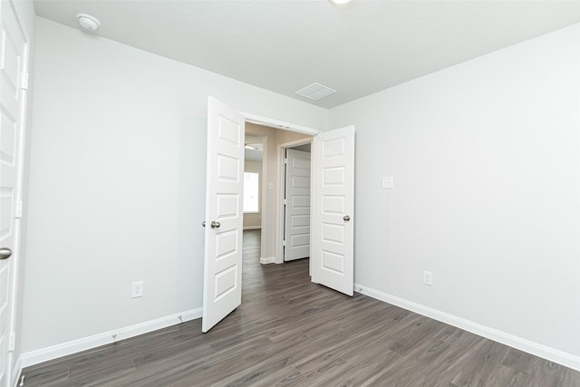 unfurnished bedroom featuring dark hardwood / wood-style flooring