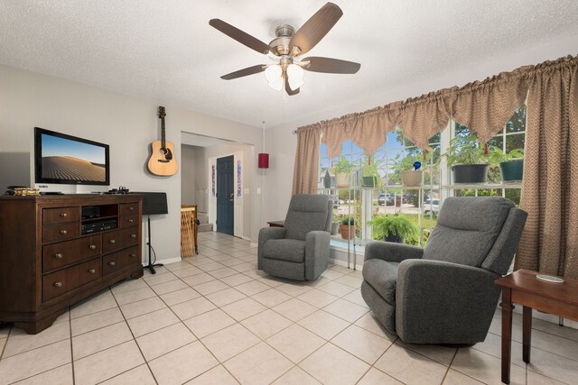 living area featuring a textured ceiling, ceiling fan, and light tile patterned flooring