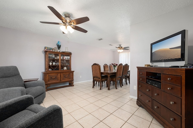 living room featuring light tile patterned floors, a textured ceiling, and ceiling fan