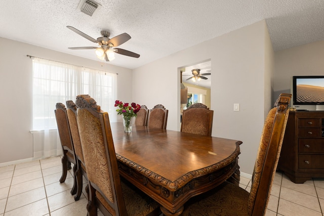 tiled dining space featuring ceiling fan and a textured ceiling