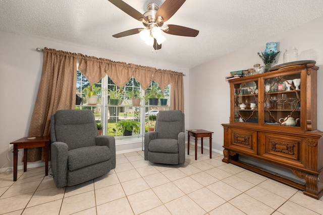 sitting room featuring light tile patterned floors, a textured ceiling, and ceiling fan