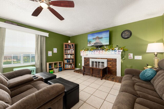 tiled living room featuring a textured ceiling, a brick fireplace, and ceiling fan