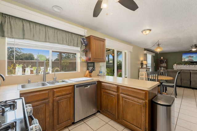 kitchen with dishwasher, kitchen peninsula, a textured ceiling, and a wealth of natural light