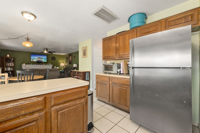 kitchen with ceiling fan, stainless steel fridge, light tile patterned flooring, and a textured ceiling