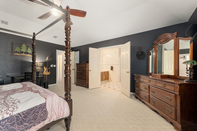 bedroom featuring ensuite bath, ceiling fan, light colored carpet, and a textured ceiling