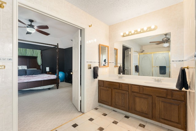 bathroom featuring vanity, ceiling fan, a textured ceiling, and walk in shower