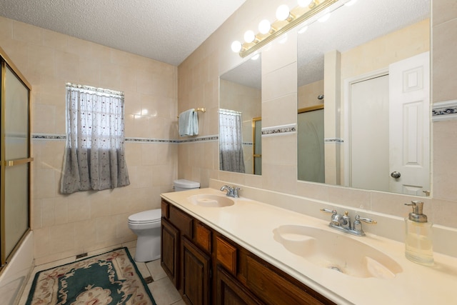 full bathroom with combined bath / shower with glass door, tile patterned floors, a textured ceiling, tile walls, and toilet