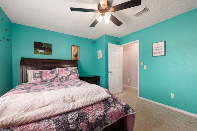 carpeted bedroom featuring ceiling fan and a textured ceiling