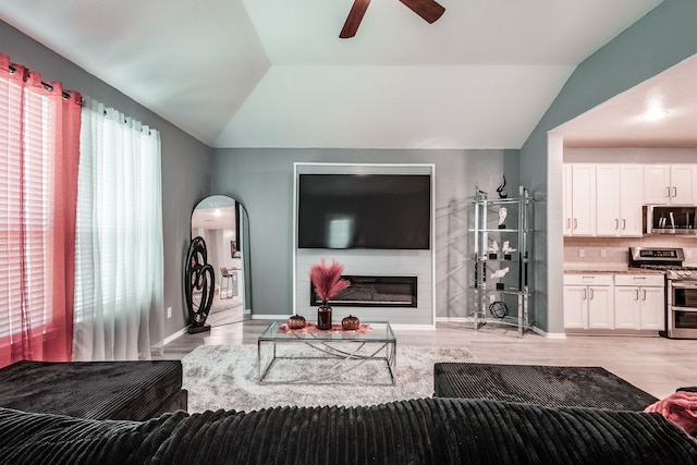 living room with ceiling fan, lofted ceiling, and light hardwood / wood-style flooring