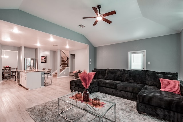 living room with light wood-type flooring, vaulted ceiling, ceiling fan, and sink