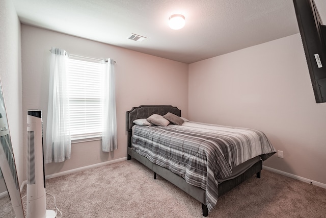 bedroom with light colored carpet and multiple windows