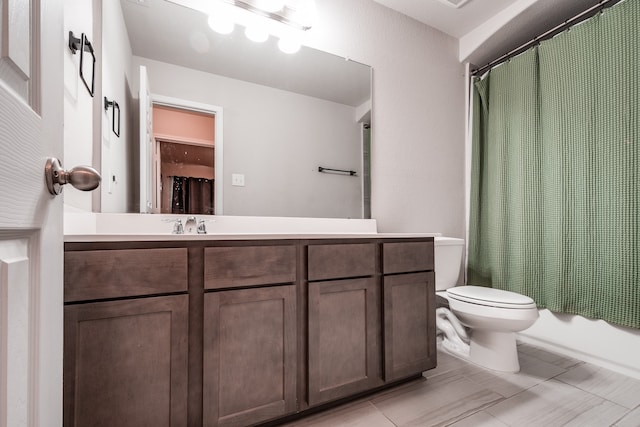 full bathroom featuring vanity, shower / tub combo, and toilet