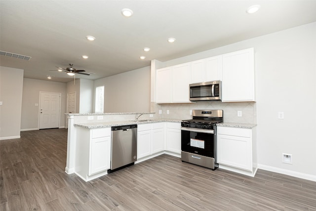 kitchen featuring kitchen peninsula, stainless steel appliances, ceiling fan, light hardwood / wood-style flooring, and white cabinets