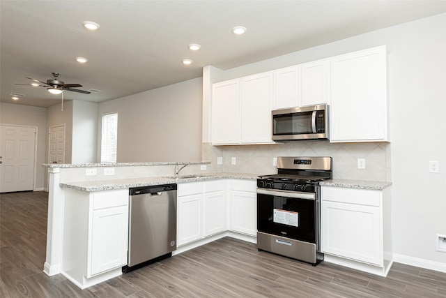 kitchen featuring white cabinets, ceiling fan, appliances with stainless steel finishes, light hardwood / wood-style floors, and kitchen peninsula