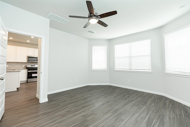 spare room with ceiling fan and dark wood-type flooring