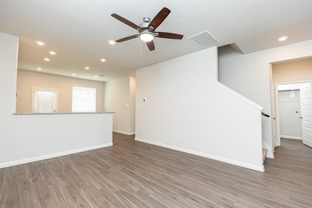 unfurnished living room featuring ceiling fan and dark hardwood / wood-style flooring