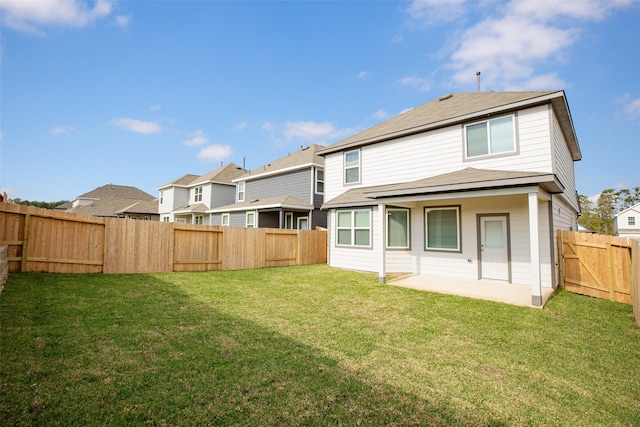 rear view of house with a yard and a patio