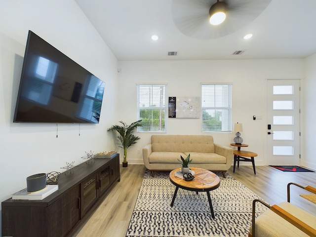 living room featuring light wood-type flooring and ceiling fan