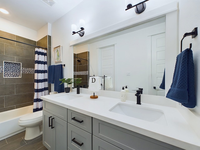 full bathroom with vanity, shower / bath combo, and toilet