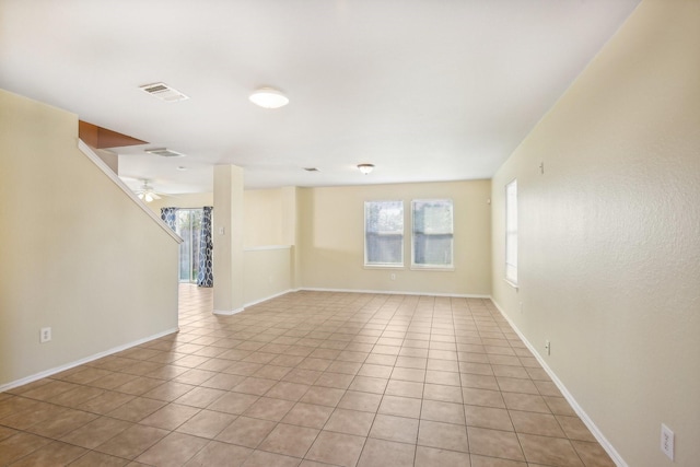 spare room featuring visible vents, ceiling fan, baseboards, and light tile patterned flooring