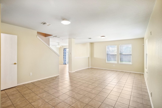 spare room featuring baseboards, visible vents, a ceiling fan, and light tile patterned flooring