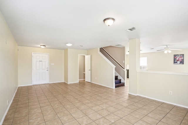 interior space with baseboards, stairs, visible vents, and a ceiling fan