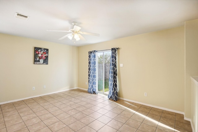 empty room featuring ceiling fan, light tile patterned floors, visible vents, and baseboards