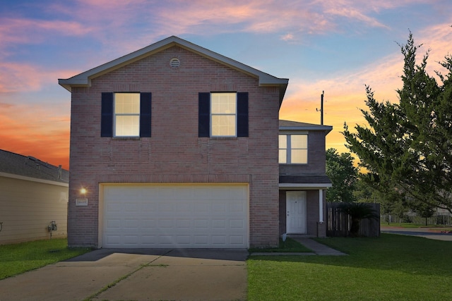 traditional-style house with a garage, brick siding, a yard, and driveway