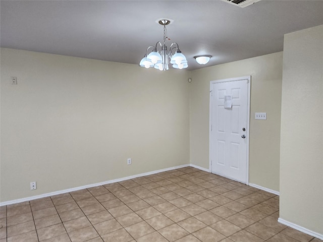 empty room with baseboards and a chandelier