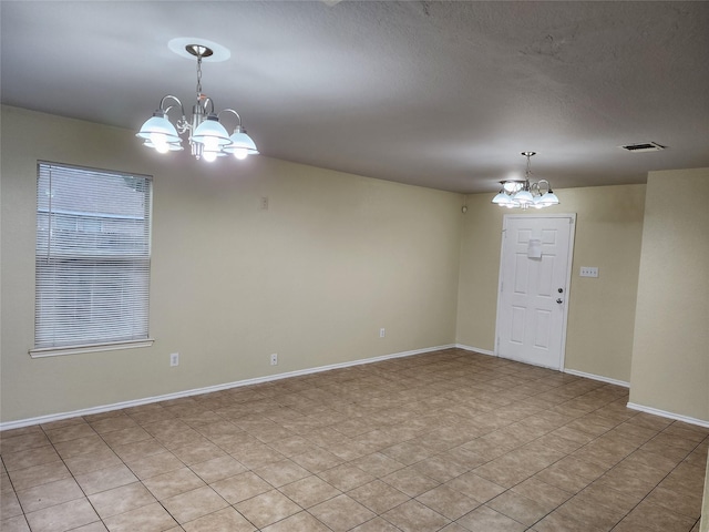 interior space featuring an inviting chandelier, baseboards, visible vents, and a textured ceiling