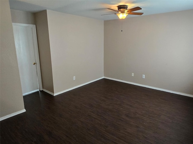 empty room with a ceiling fan, baseboards, and dark wood-type flooring