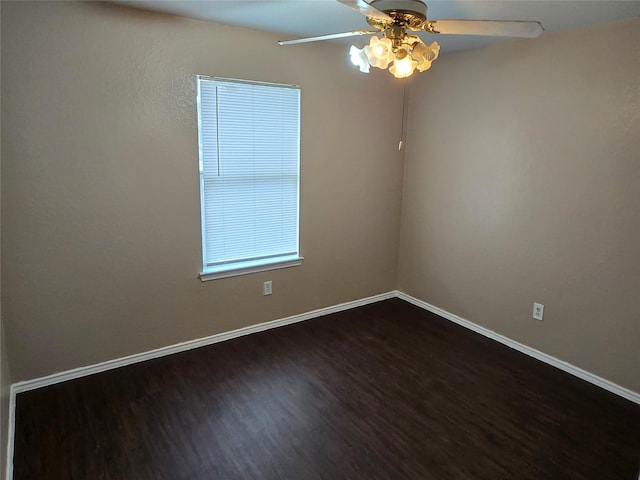 empty room with baseboards, dark wood finished floors, and a ceiling fan