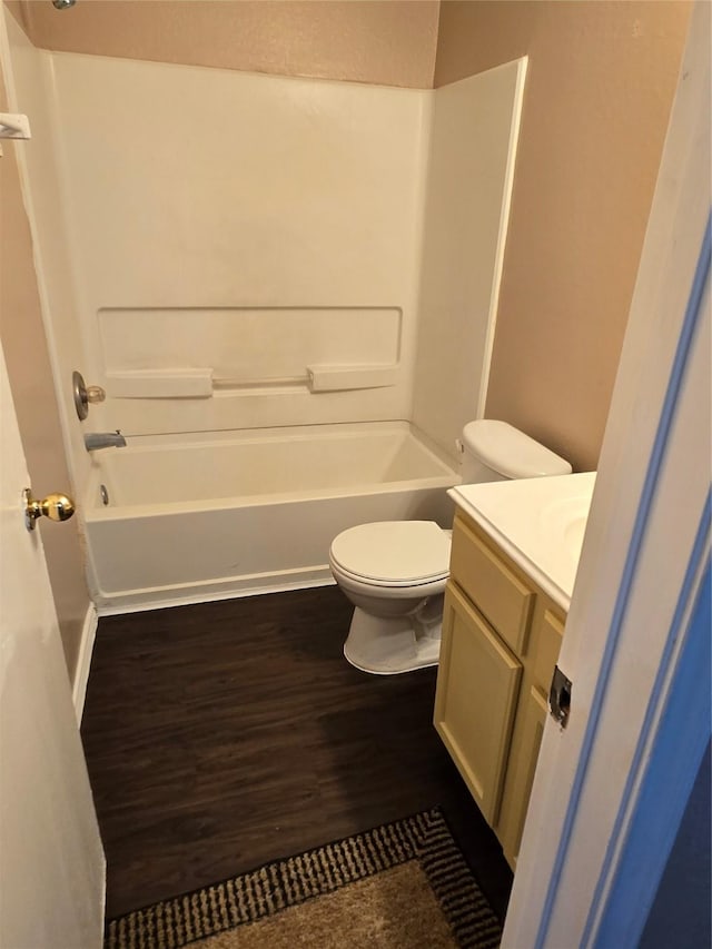 bathroom with wood finished floors, vanity, toilet, and shower / bathtub combination