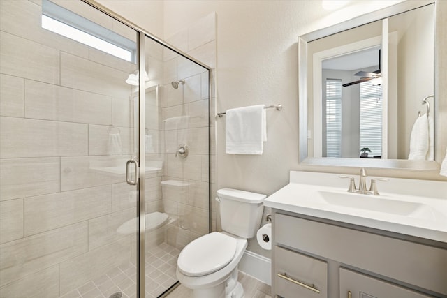 bathroom with vanity, toilet, a shower with door, and a wealth of natural light