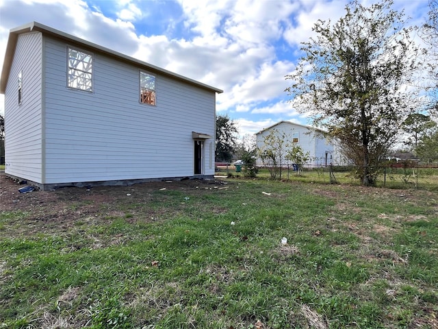 back of property featuring a yard and fence