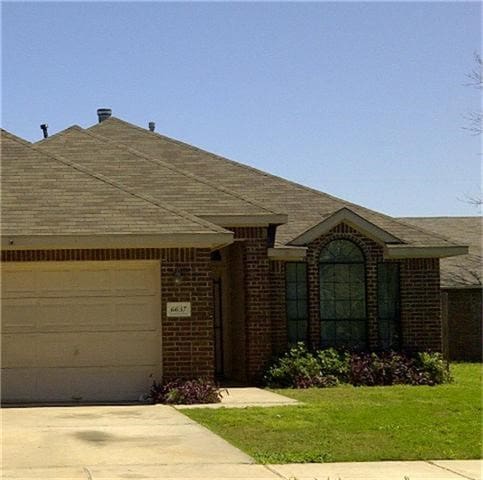 ranch-style house with a front yard and a garage