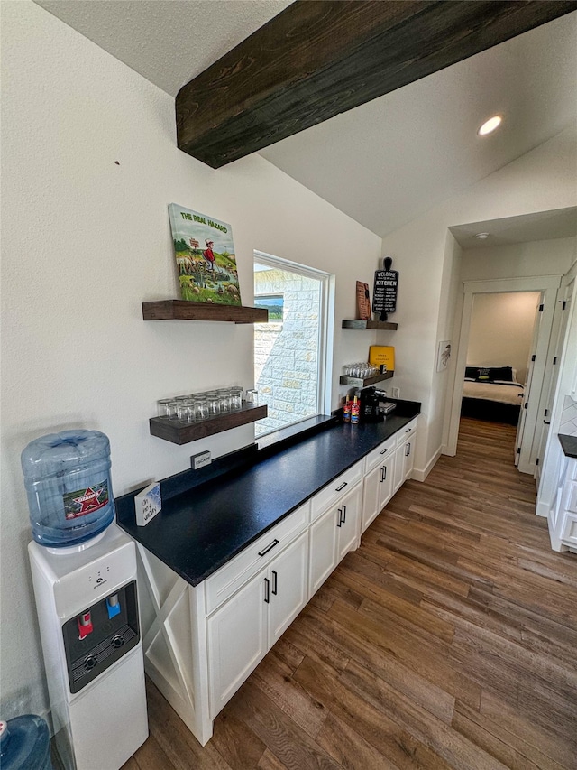 kitchen featuring dark hardwood / wood-style flooring, white cabinetry, and vaulted ceiling